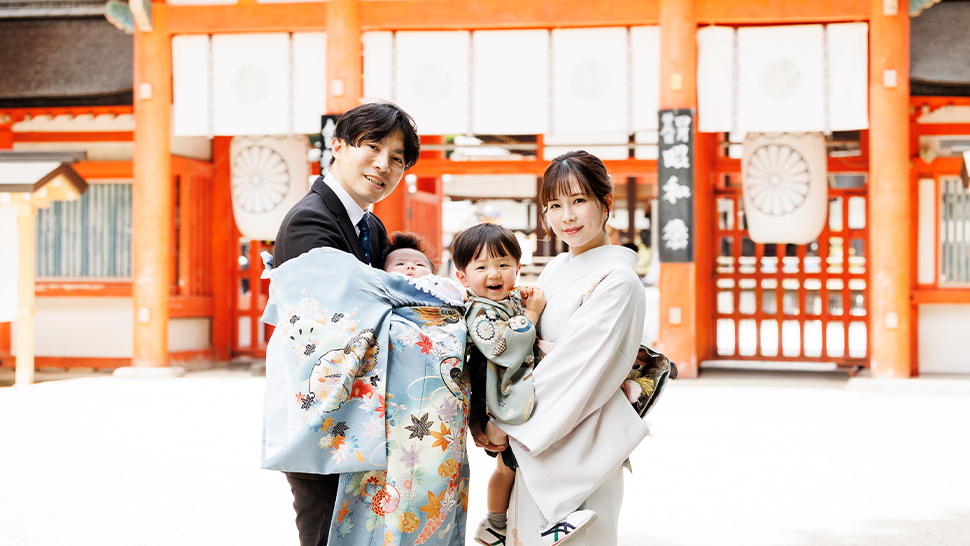 京都のスタジオクレアーレでお宮参りの記念撮影をした、産着姿の赤ちゃんとご両親の家族集合写真
