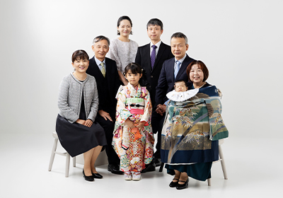 京都のスタジオクレアーレでお宮参りの記念撮影をした、産着姿の赤ちゃんとご両親・祖父母の家族集合写真